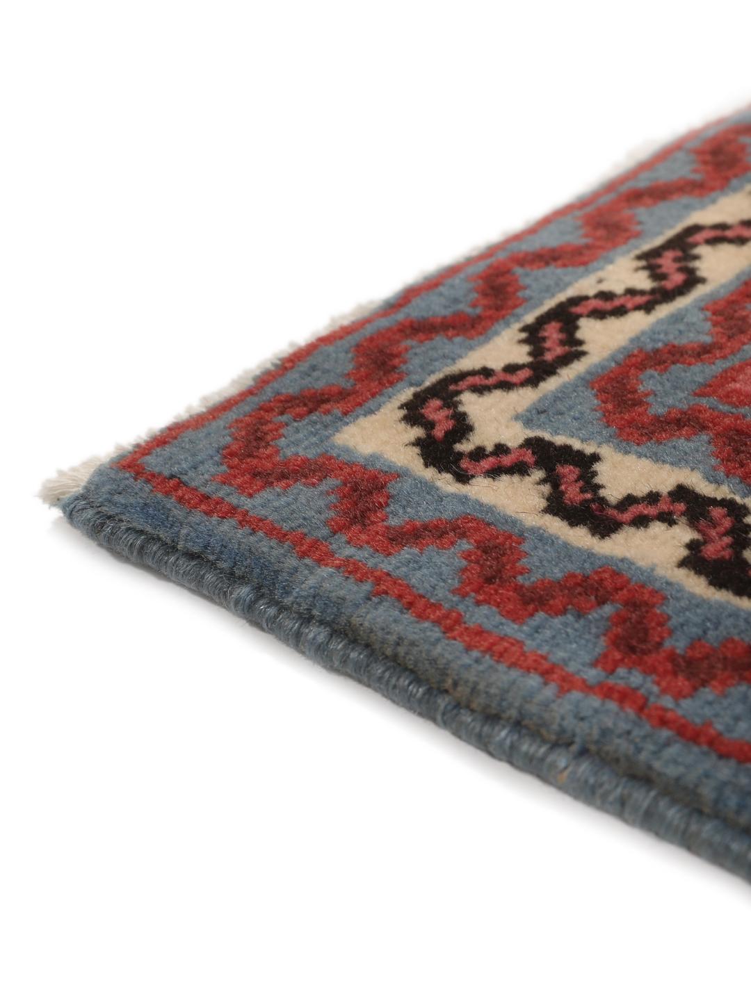 Een klein handgeknoopt Hosseinabad-tapijt uit het Midden-Oosten met een blauw en rood geometrisch patroon