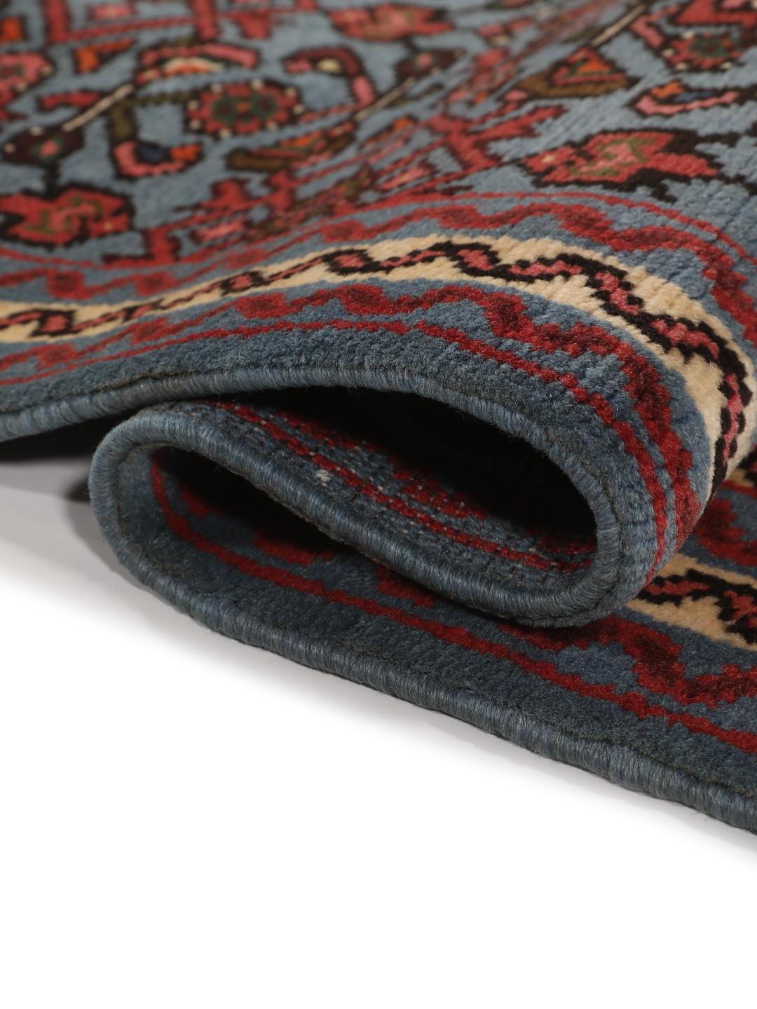 Een klein handgeknoopt Hosseinabad-tapijt uit het Midden-Oosten met een blauw en rood geometrisch patroon