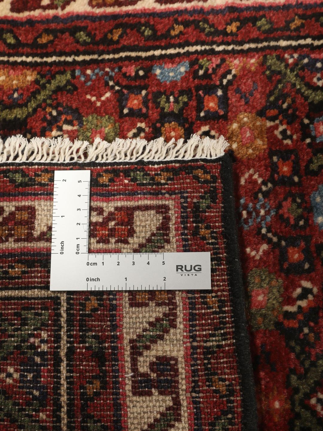 A long, hand-knotted red Hosseinabad runner with a geometric pattern.