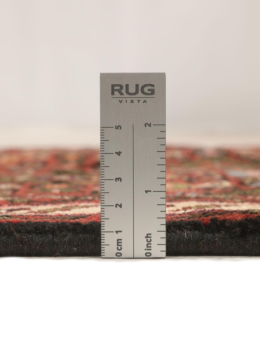 A long, hand-knotted red Hosseinabad runner with a geometric pattern.