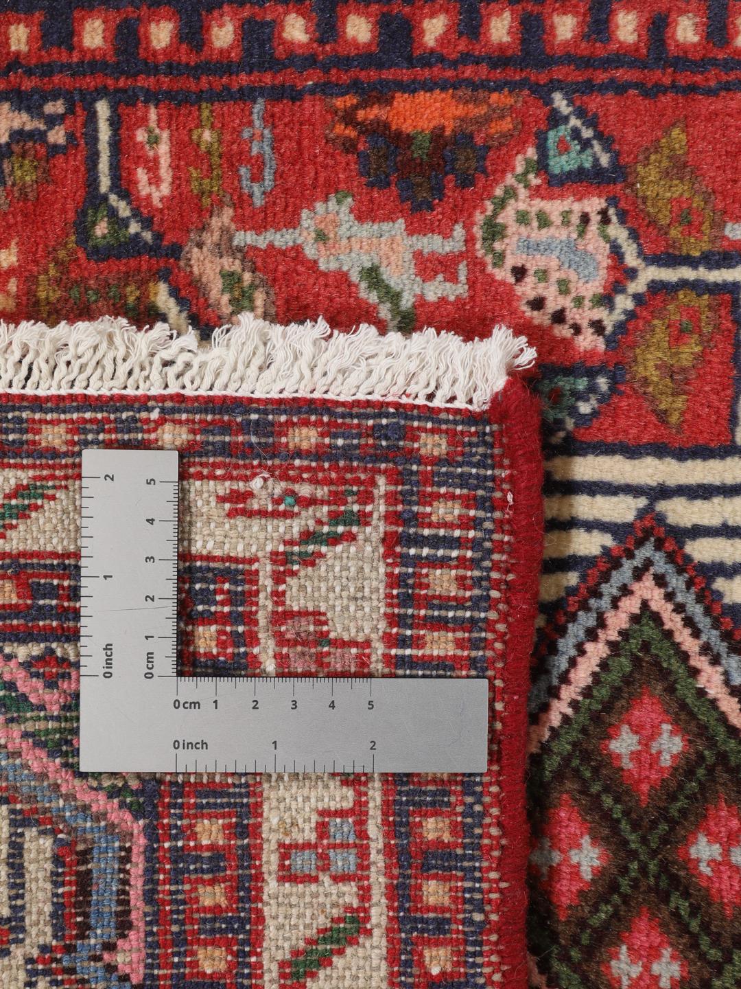 Hand-knotted Asadabad rug from the Middle East with a vibrant red field and geometric patterns