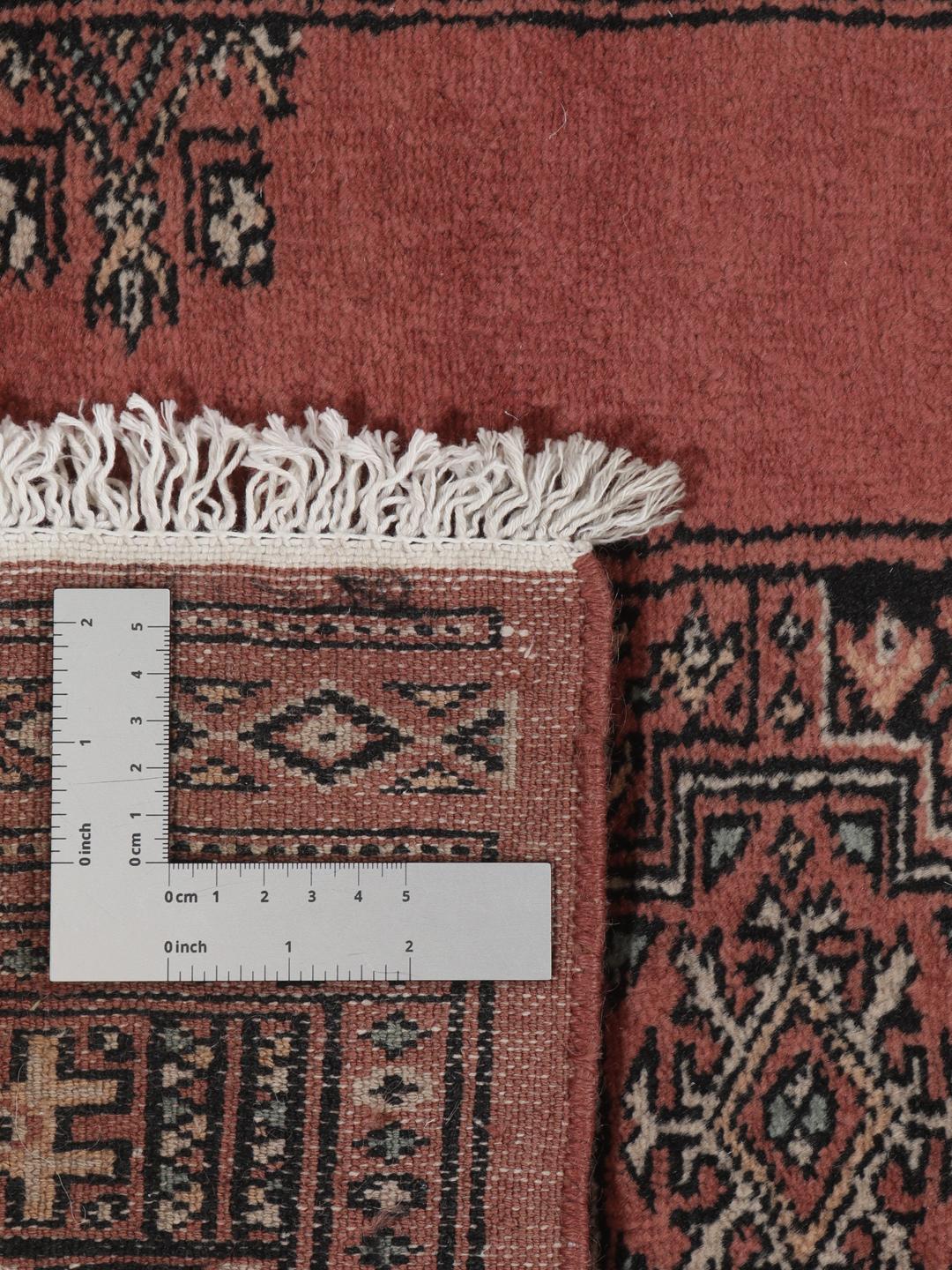 Een lange rode Pakistan Bokhara loper met herhalende geometrische patronen.