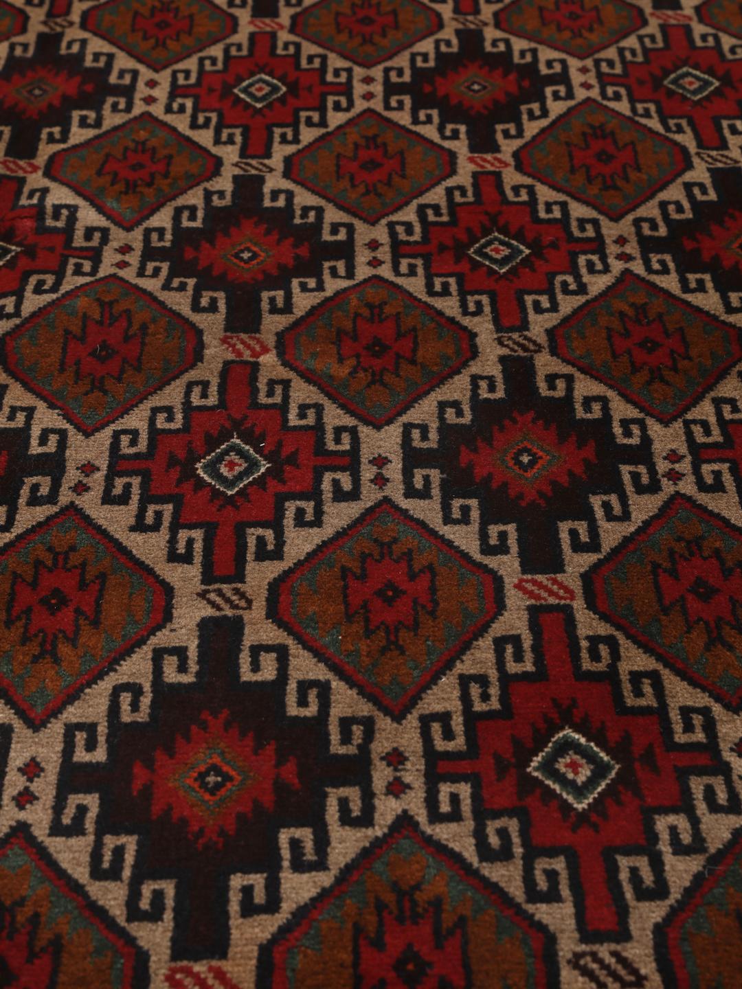 Hand-knotted Baluch rug from the Middle East in deep red and black tones