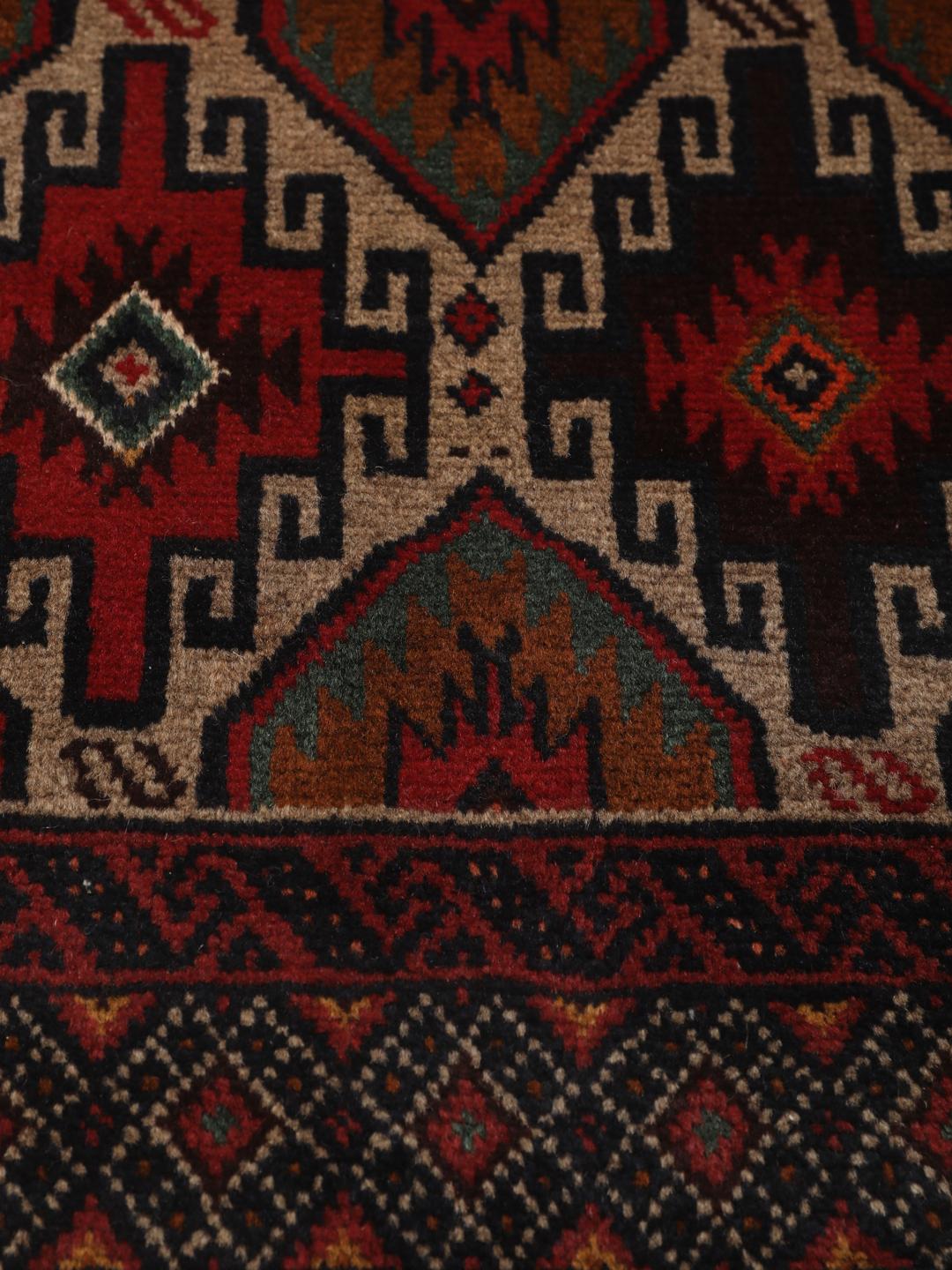 Hand-knotted Baluch rug from the Middle East in deep red and black tones