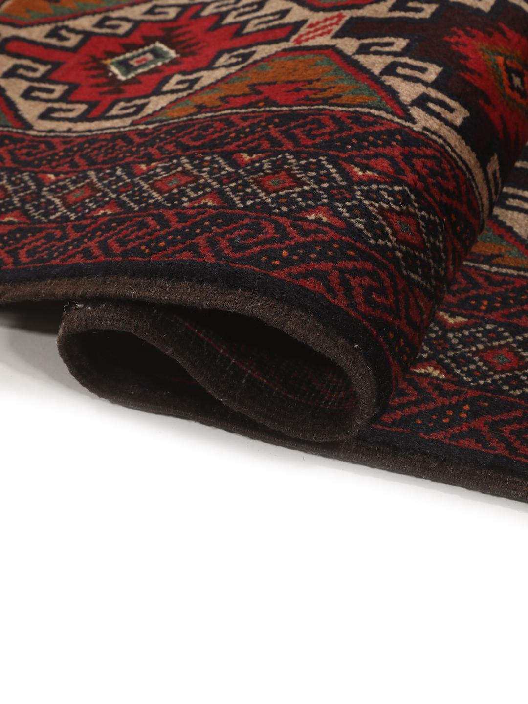 Hand-knotted Baluch rug from the Middle East in deep red and black tones