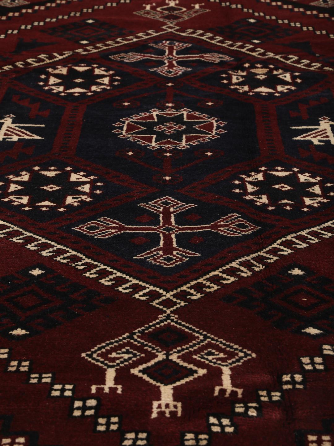 A hand-knotted Lori rug from the Middle East featuring a dark-red and black geometric pattern.