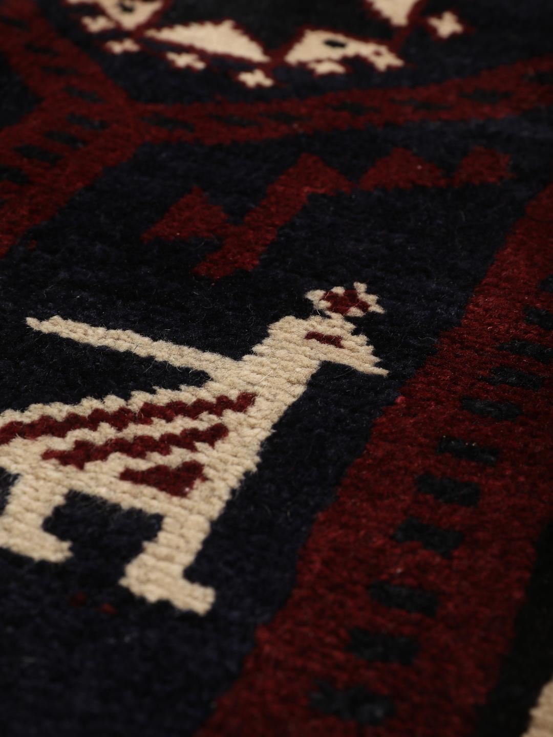 A hand-knotted Lori rug from the Middle East featuring a dark-red and black geometric pattern.