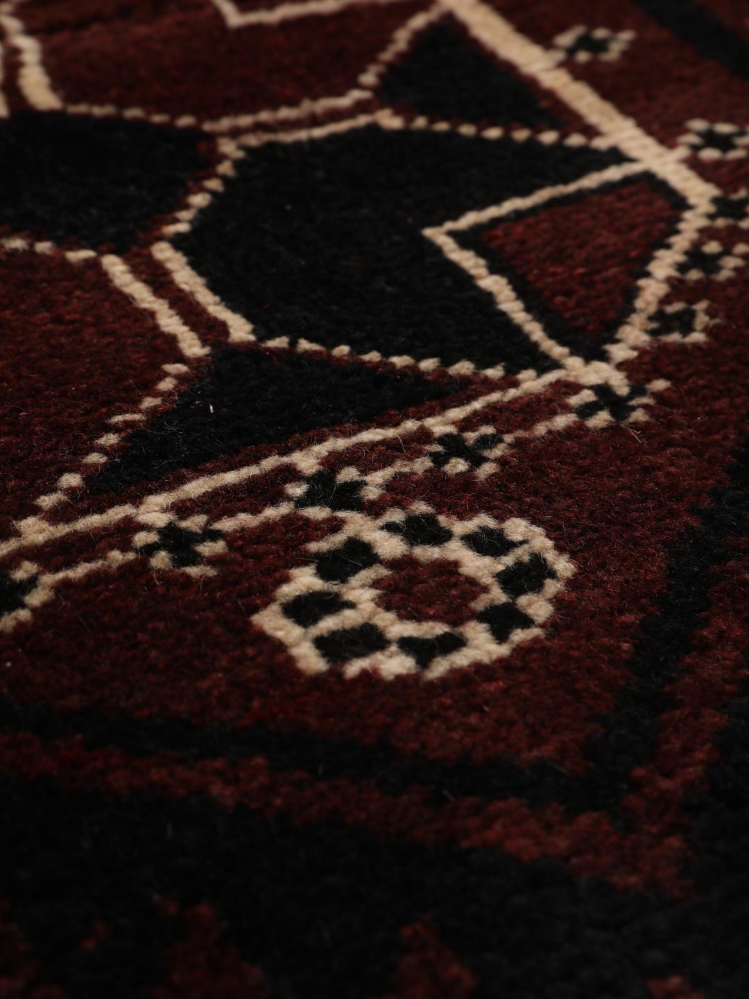 Håndknyttet Lori-tæppe fra Mellemøsten med en mørkerød uldluve.