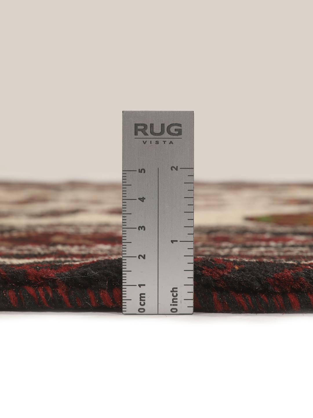 Et håndknyttet Baluch-tæppe fra Mellemøsten med et mørkerødt og beige tribal-design