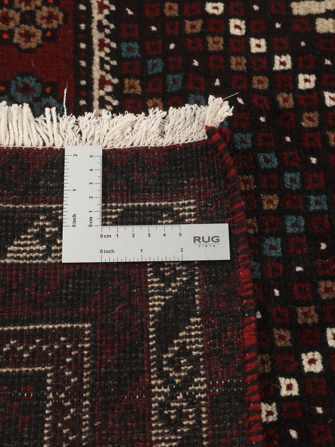 Et håndknyttet Baluch-tæppe fra Mellemøsten med et mørkerødt og beige tribal-design