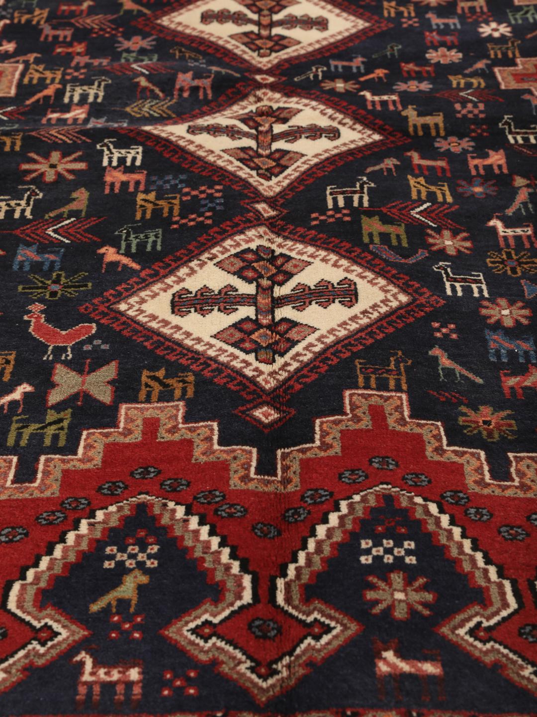 Hand-knotted Afshar rug from the Middle East featuring a red and blue field with tribal animal motifs.