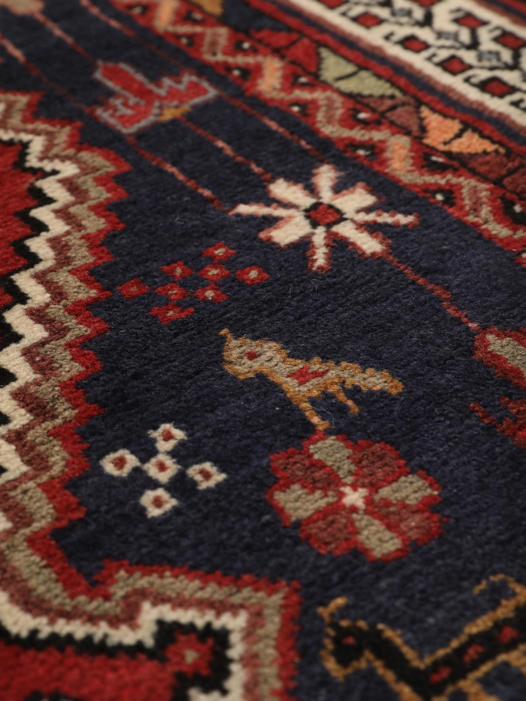 Hand-knotted Afshar rug from the Middle East featuring a red and blue field with tribal animal motifs.