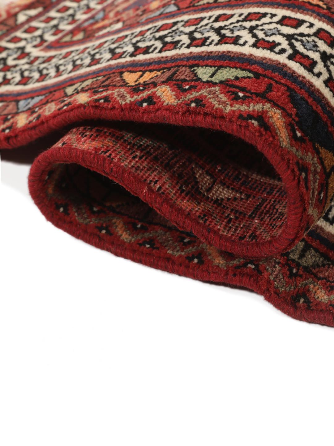 Hand-knotted Afshar rug from the Middle East featuring a red and blue field with tribal animal motifs.