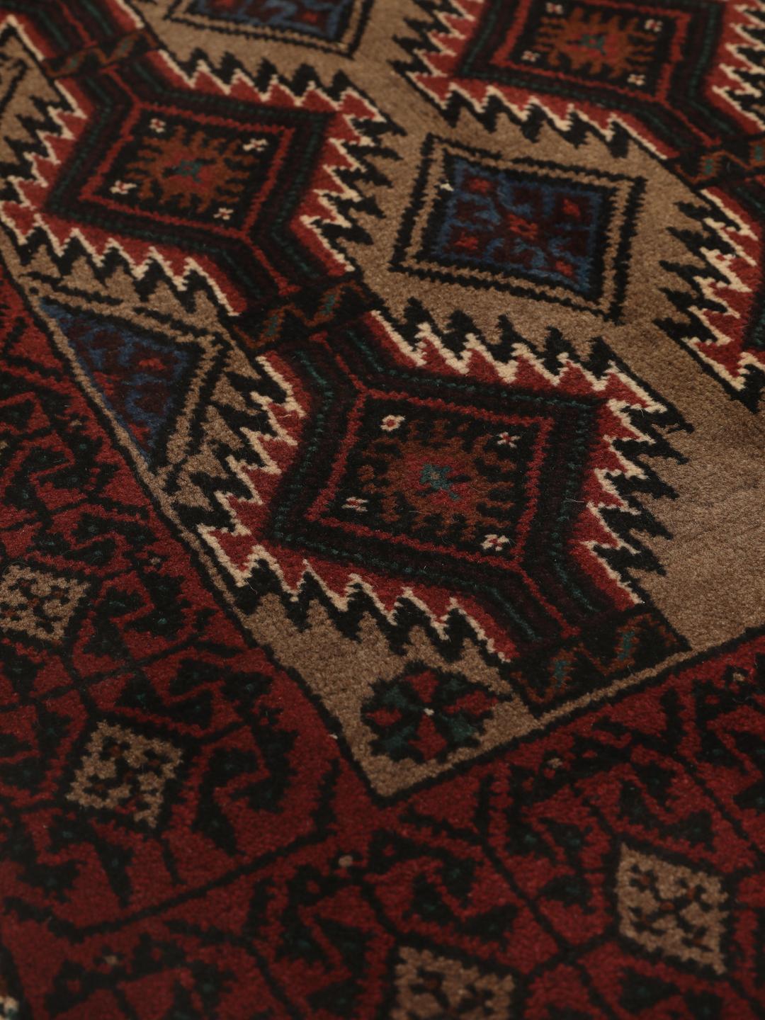 Hand-knotted Beluch rug from the Middle East in dark-red and beige