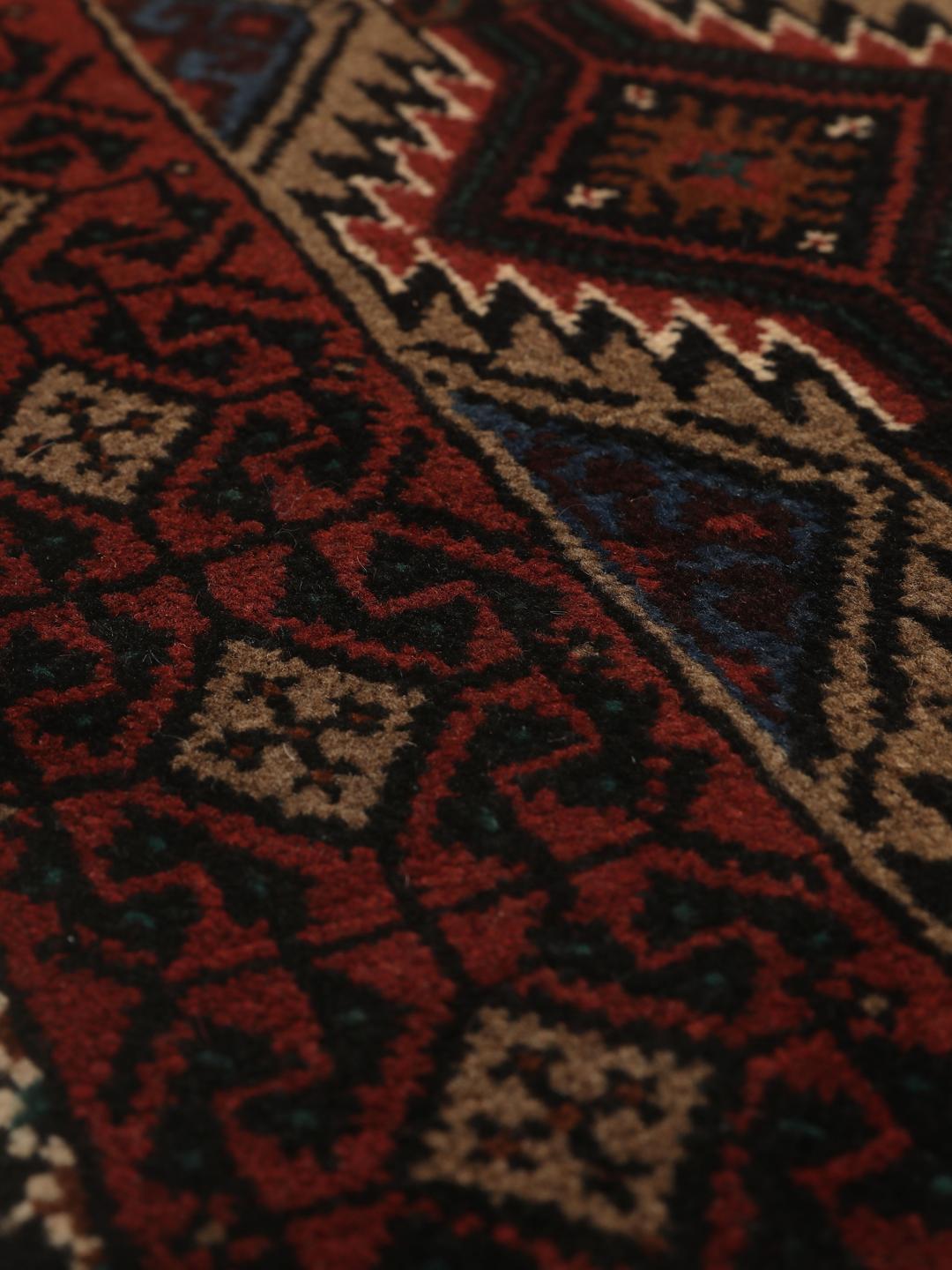 Hand-knotted Beluch rug from the Middle East in dark-red and beige