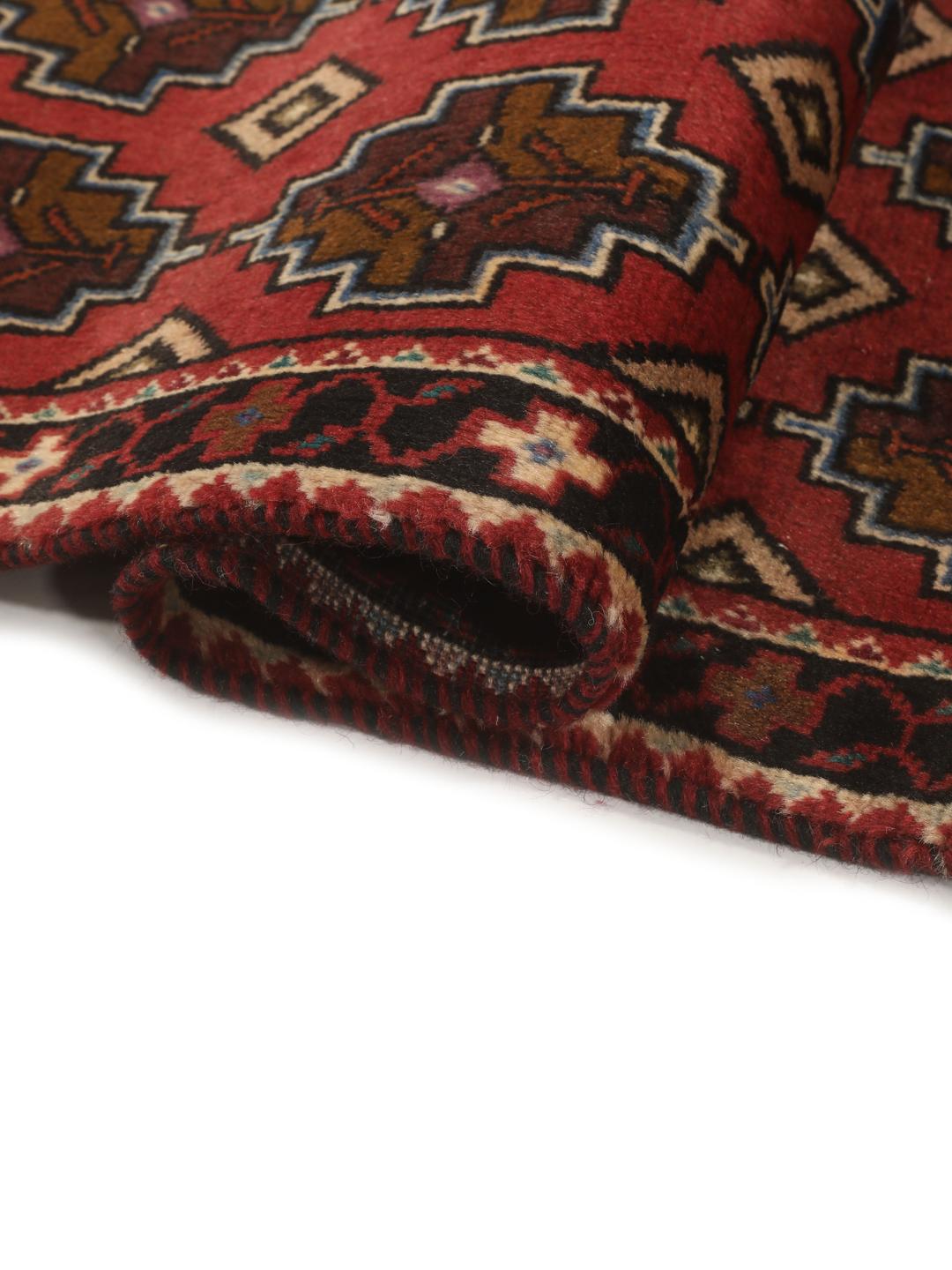 Hand knotted Baluch rug from the Middle East in dark-red with geometric motifs