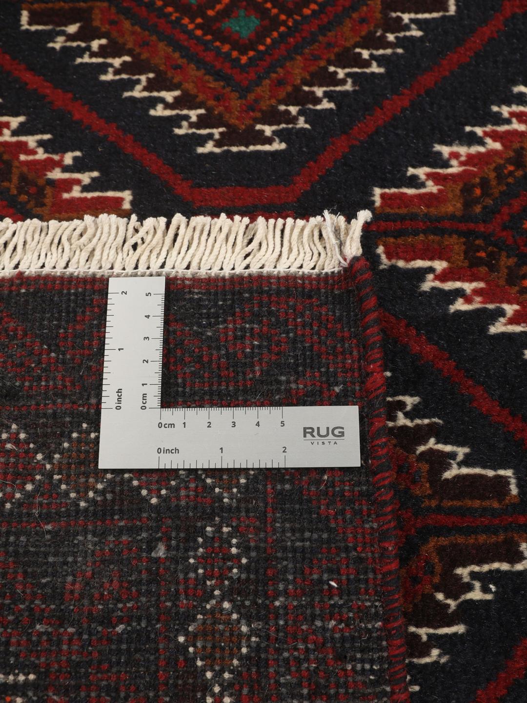 Handgeknoopt Beluch-tapijt uit het Midden-Oosten in donkerrode en donkerblauwe tinten met geometrische motieven.