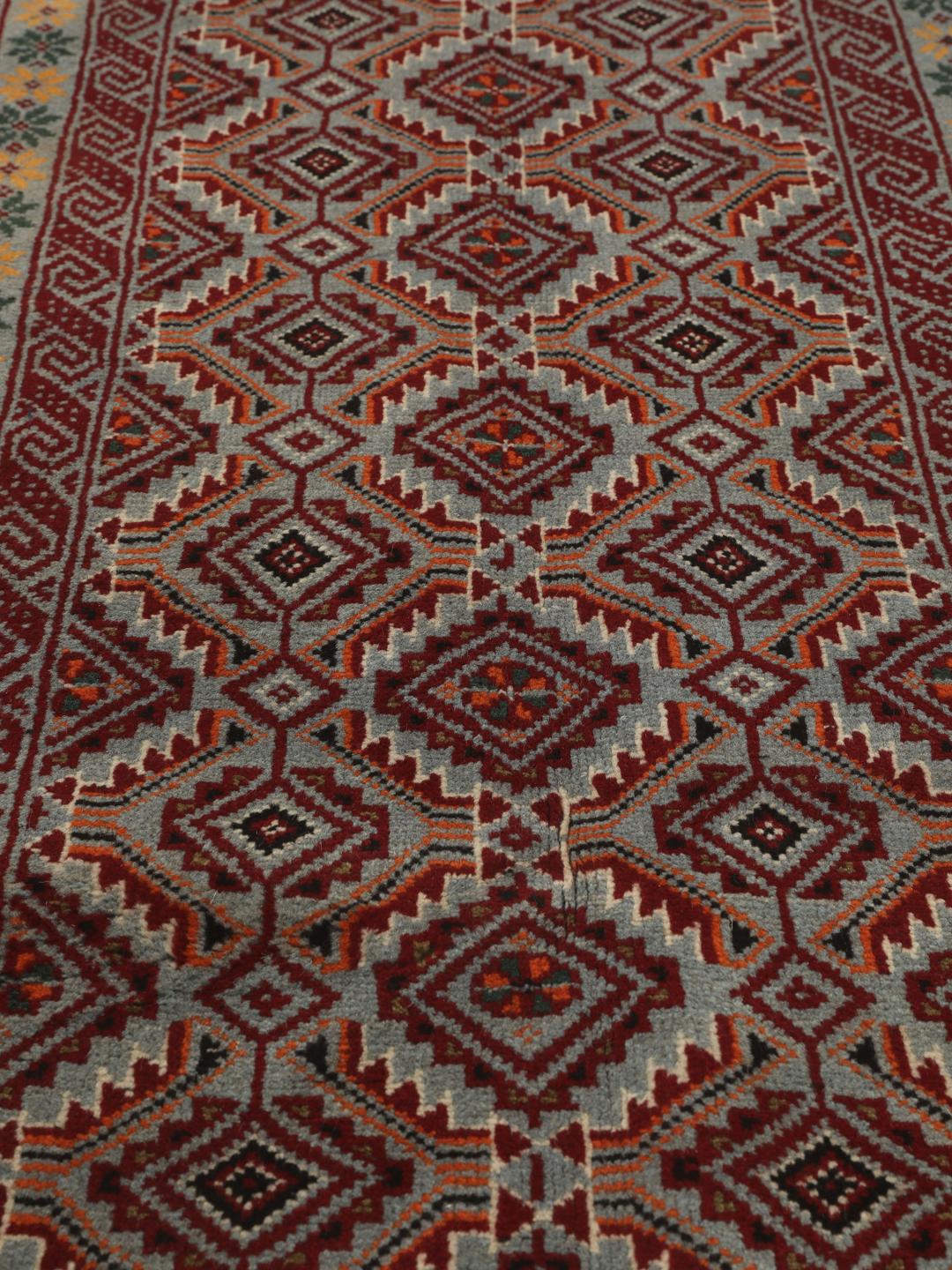 Hand-knotted Baluch rug with geometric patterns in red and grey from the Middle East