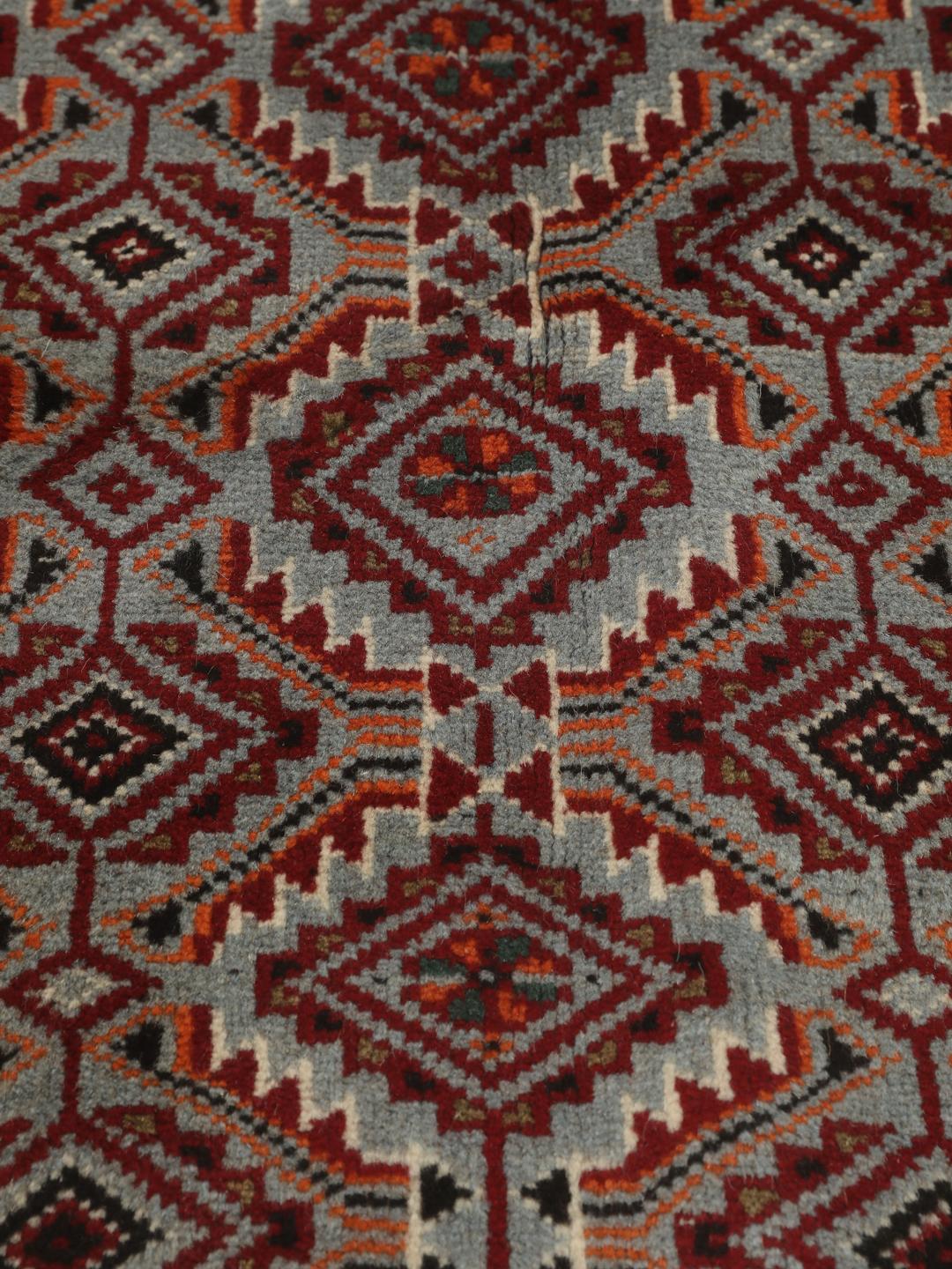 Hand-knotted Baluch rug with geometric patterns in red and grey from the Middle East