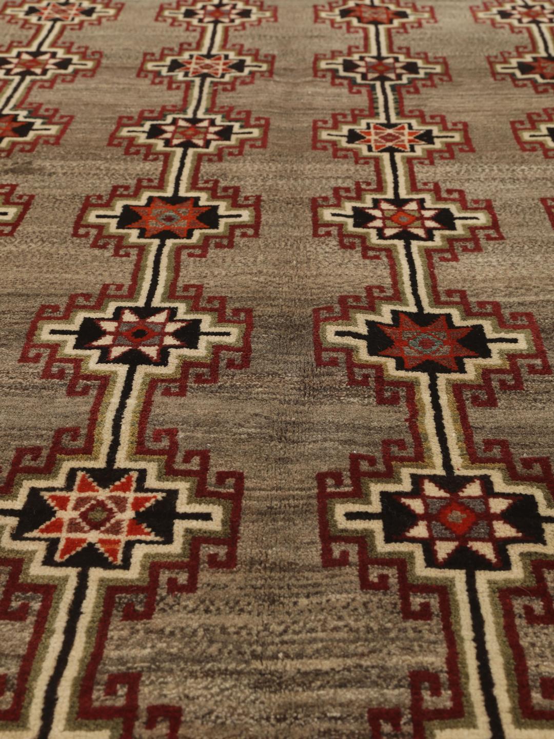 Håndknyttet Qashqai-tæppe fra Mellemøsten i brun med geometriske tribal-mønstre.