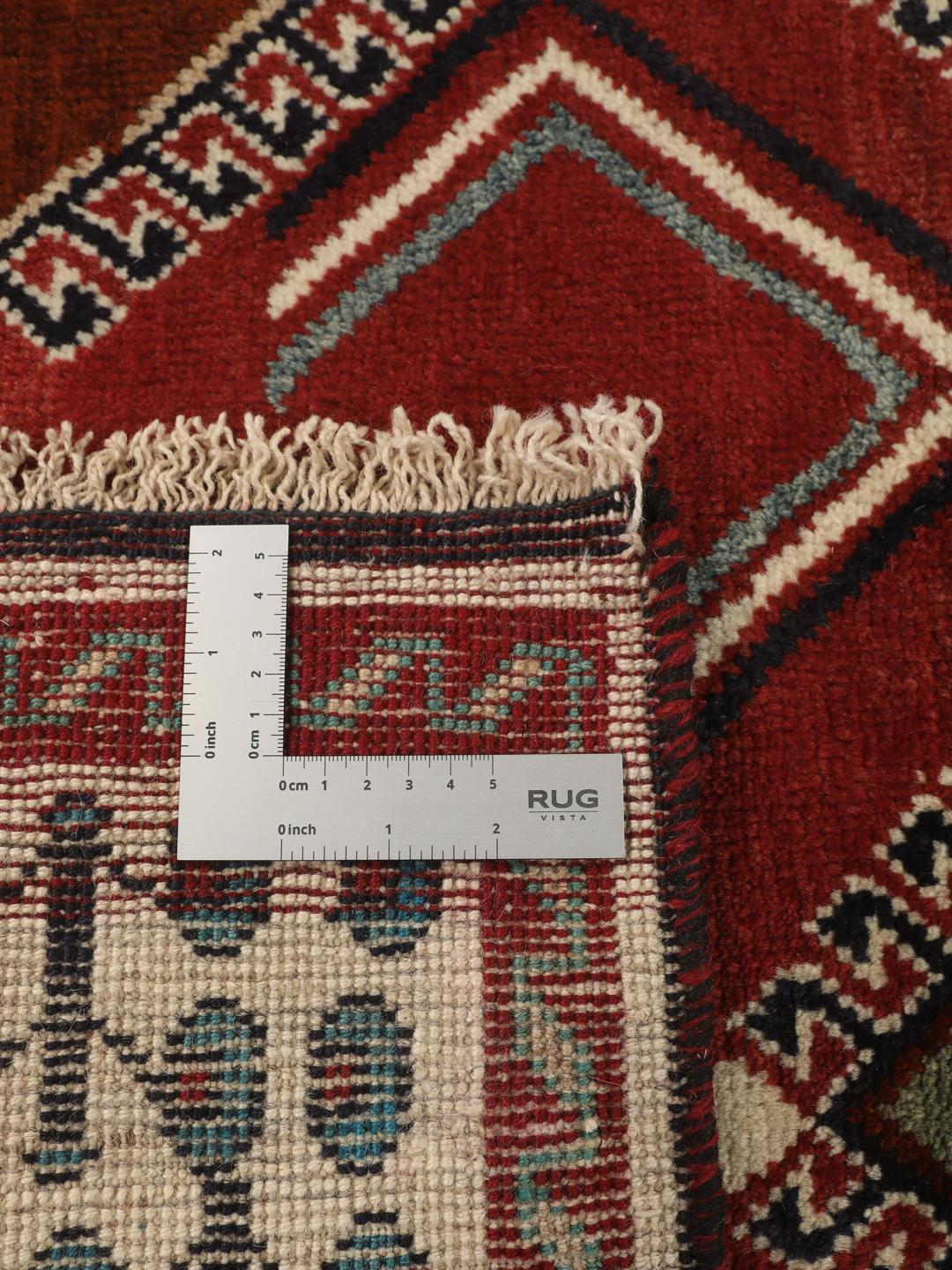 Hand-knotted Ghashghai rug from the Middle East featuring a vibrant red field with geometric diamond motifs.