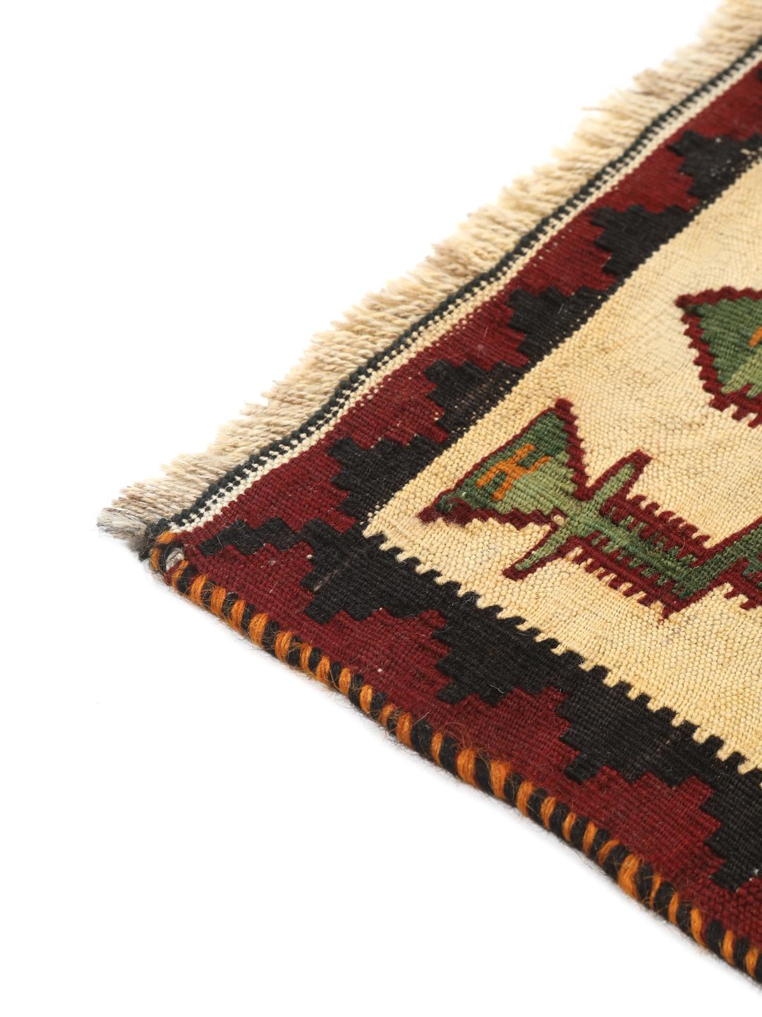 Un tapis kilim vintage tissé à la main provenant du Moyen-Orient, arborant de grands motifs géométriques en forme de losanges dans des tons rouge, vert et crème.