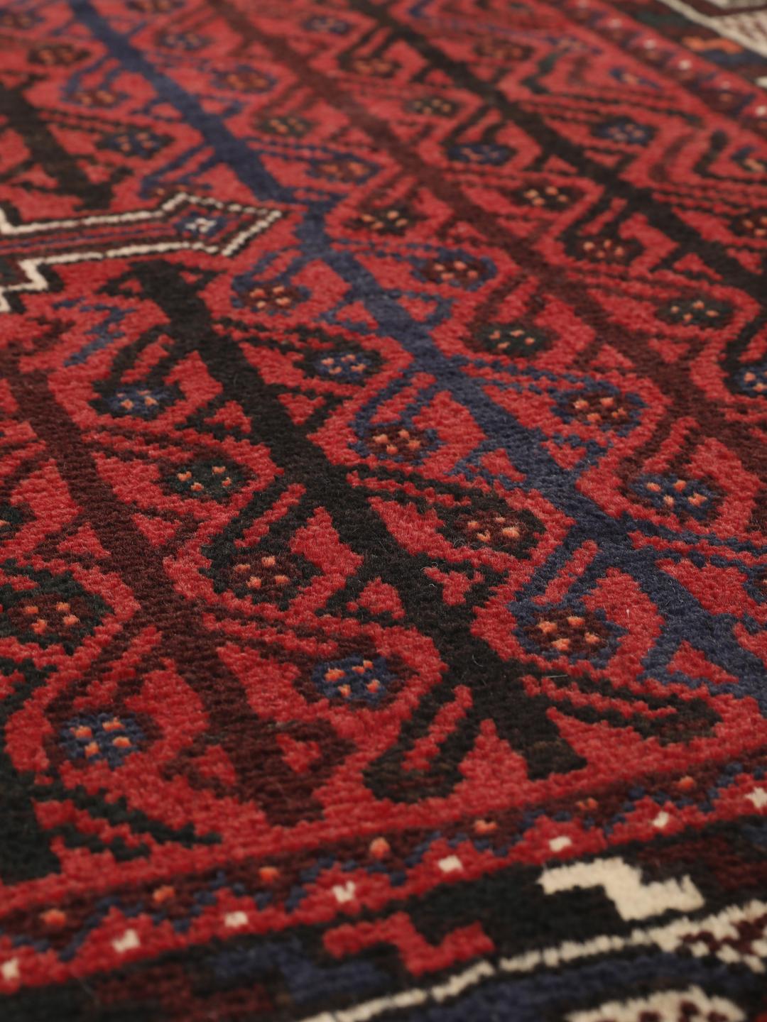 A hand-knotted Shiraz rug from the Middle East in dark-red and dark-blue tones.