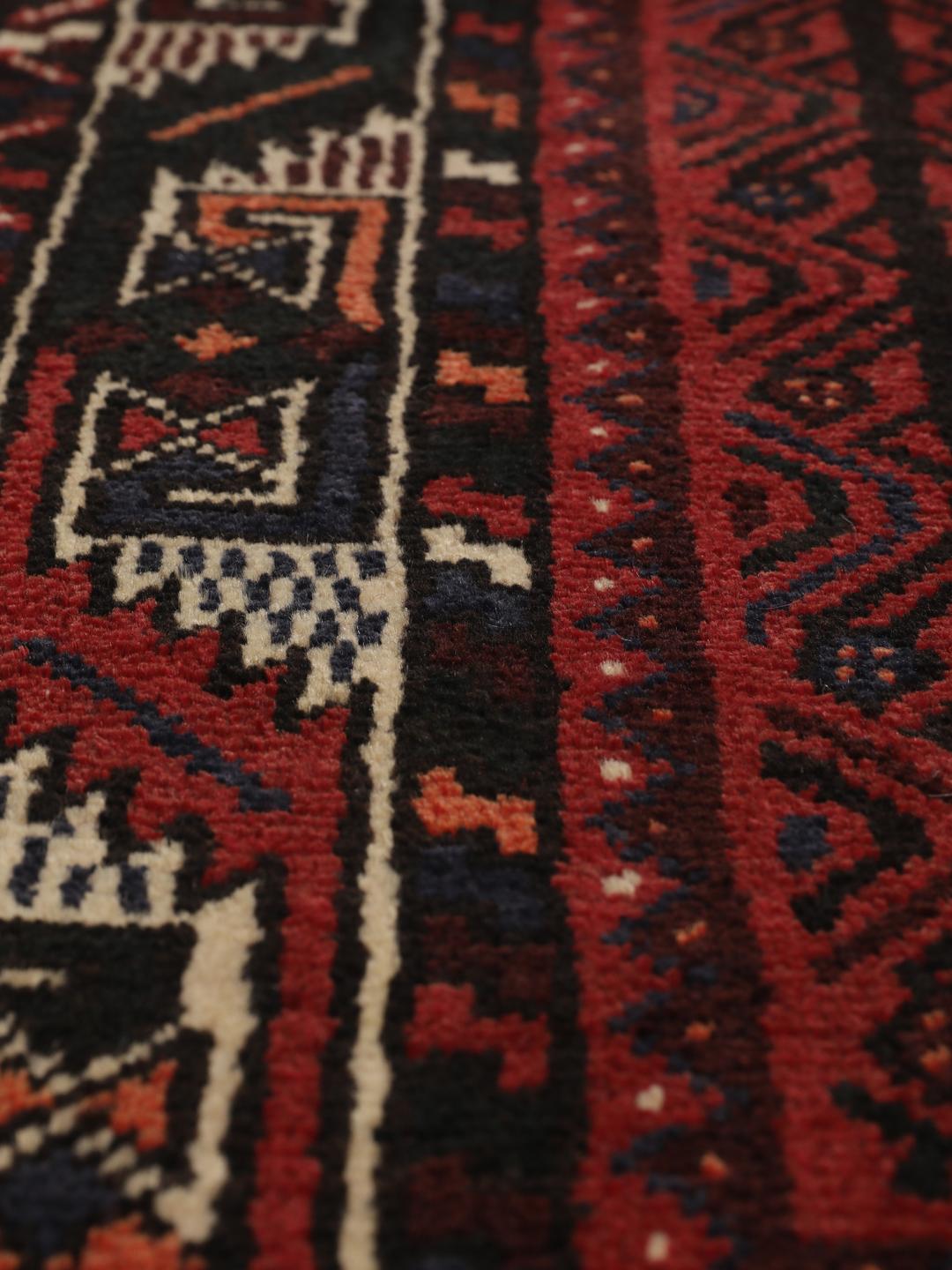 A hand-knotted Shiraz rug from the Middle East in dark-red and dark-blue tones.