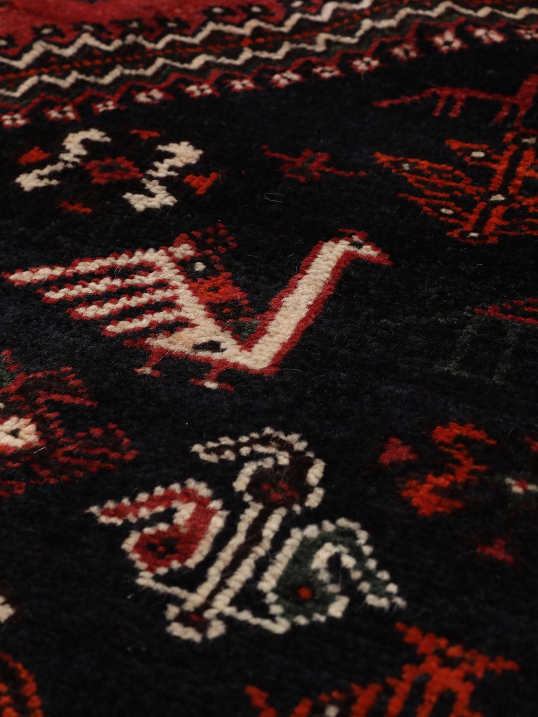 Hand-knotted Middle Eastern rug in red and black wool
