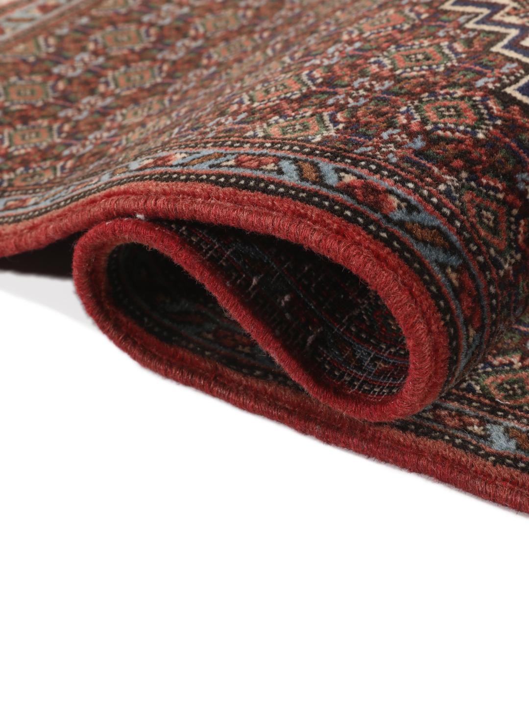 A hand-knotted Senneh rug from the Middle East in dark-red and dark-blue tones.