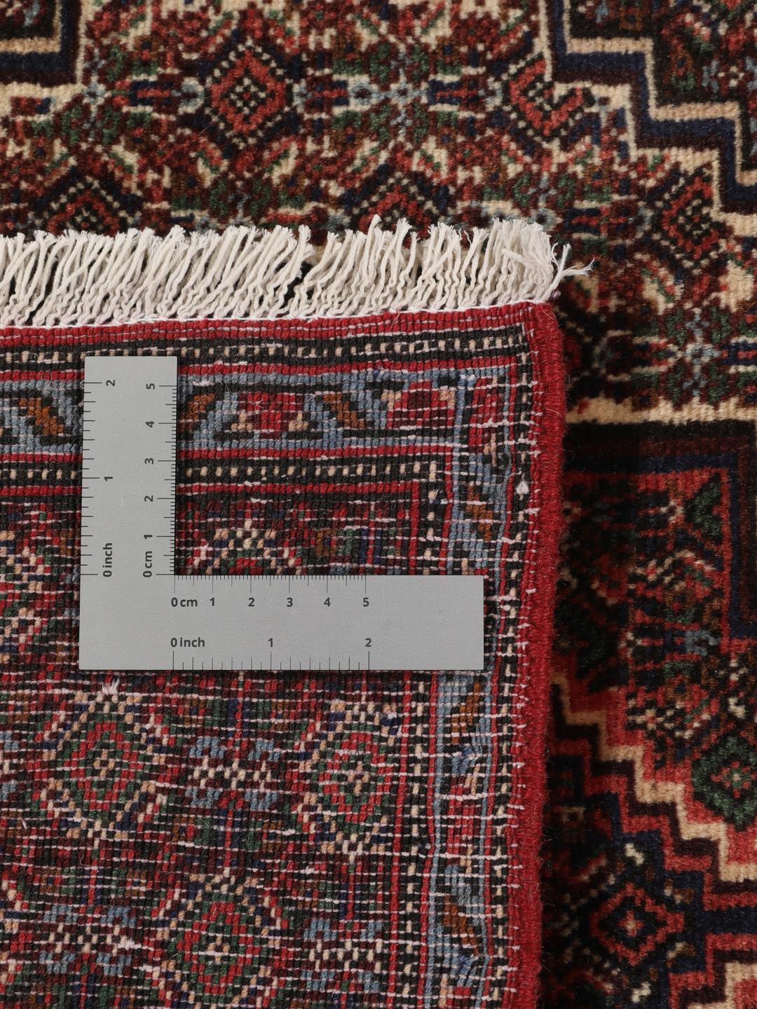 A hand-knotted Senneh rug from the Middle East in dark-red and dark-blue tones.