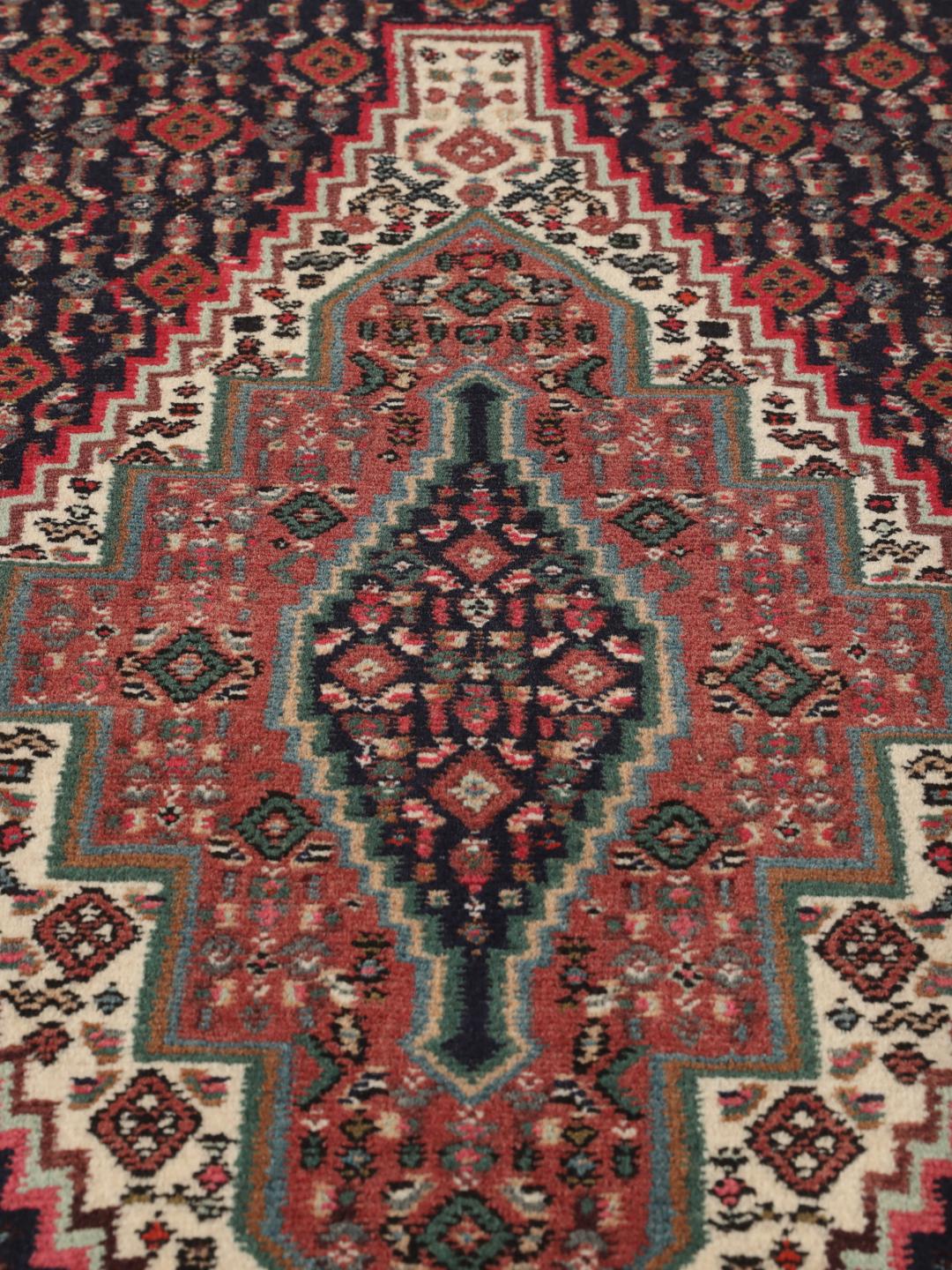 Handgeknoopt Senneh-tapijt met een donkerblauw en rood medaillonpatroon uit het Midden-Oosten