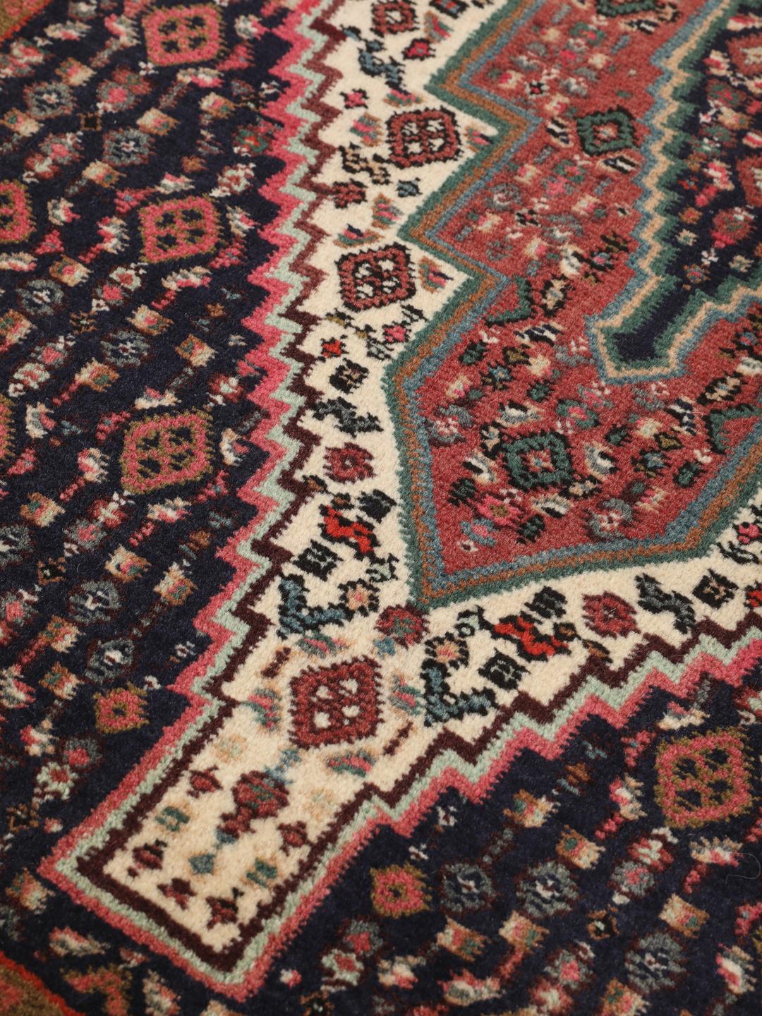 Handgeknoopt Senneh-tapijt met een donkerblauw en rood medaillonpatroon uit het Midden-Oosten