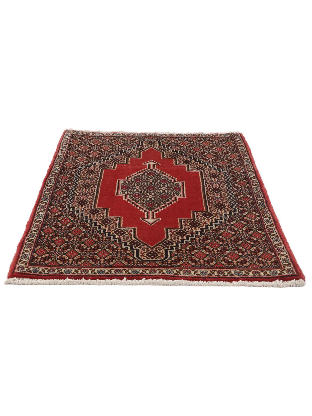 A hand-knotted Senneh rug from the Middle East in red with geometric motifs.