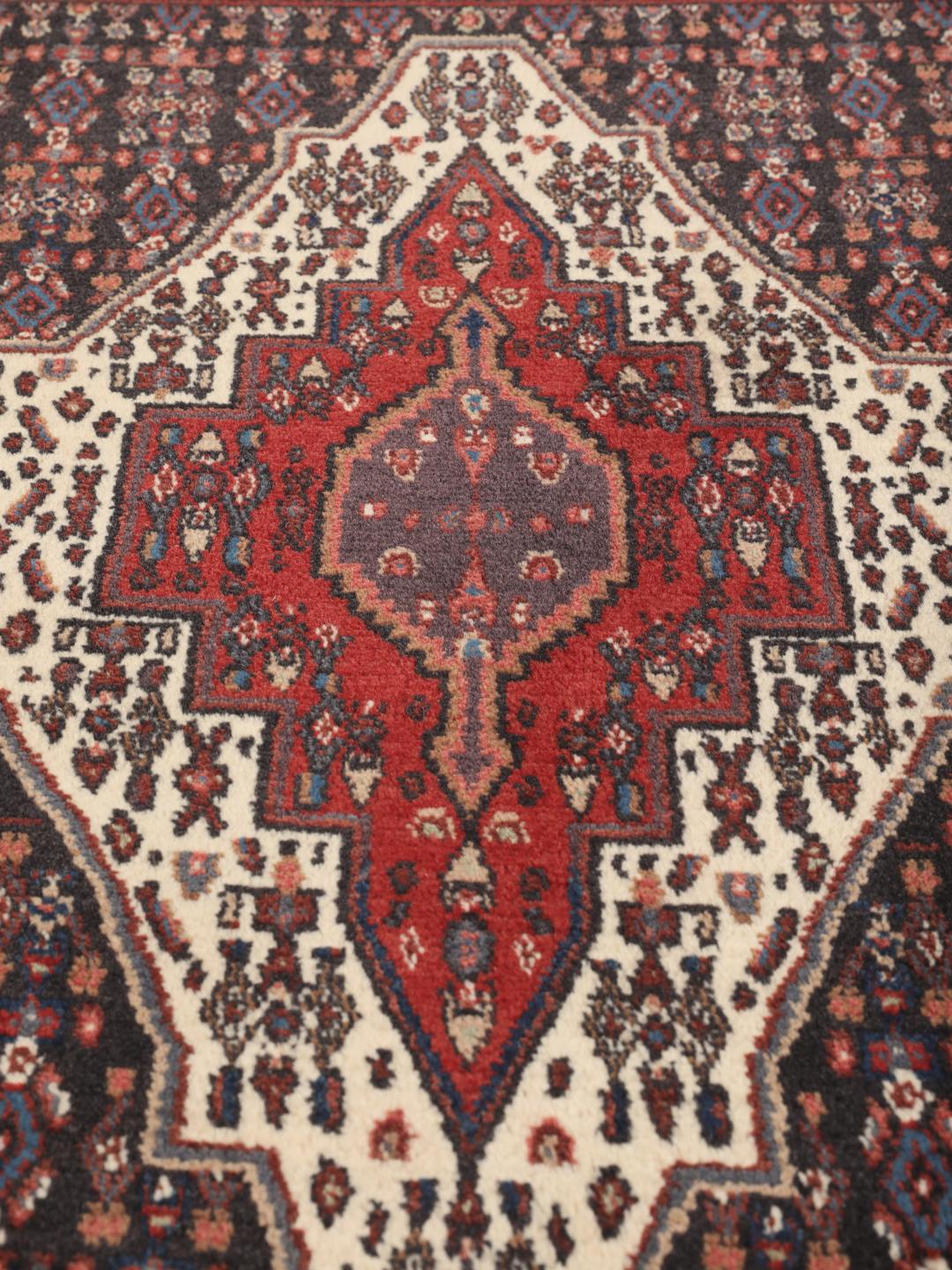 Hand-knotted Senneh rug from the Middle East in dark-blue and dark-red tones.