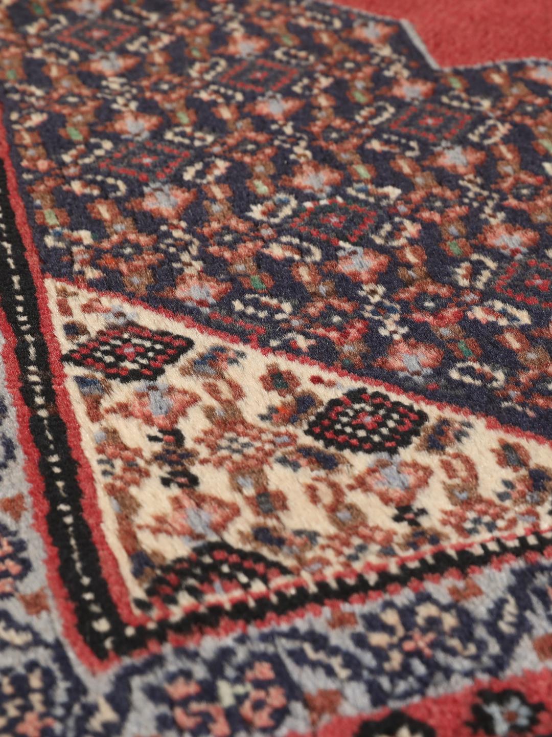 Ein handgeknüpfter Senneh-Teppich aus dem Nahen Osten mit einem roten und blauen geometrischen Design.