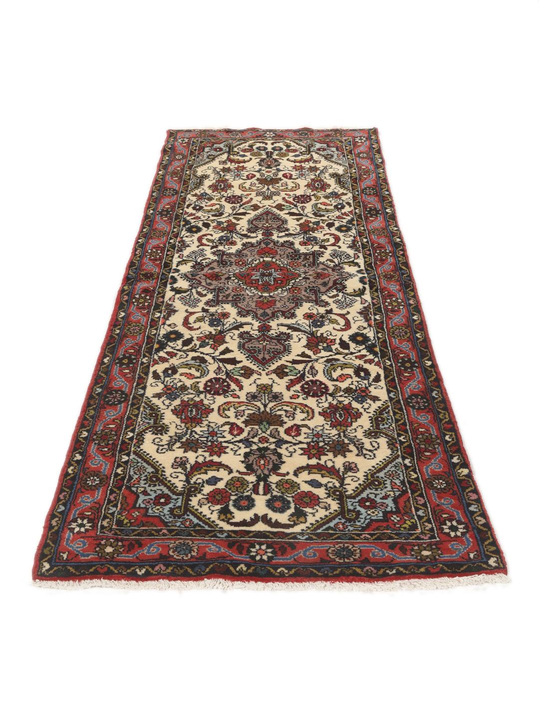 Een met de hand geknoopte Asadabad loper met een bloemmotief in beige, rode en blauwe tinten.