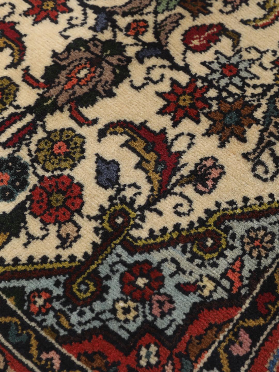Een met de hand geknoopte Asadabad loper met een bloemmotief in beige, rode en blauwe tinten.