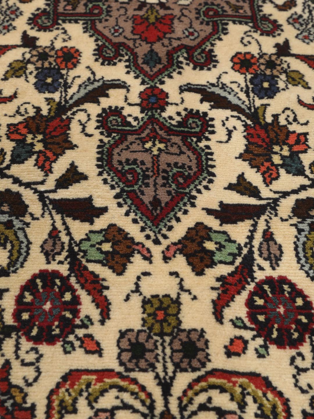 Een met de hand geknoopte Asadabad loper met een bloemmotief in beige, rode en blauwe tinten.