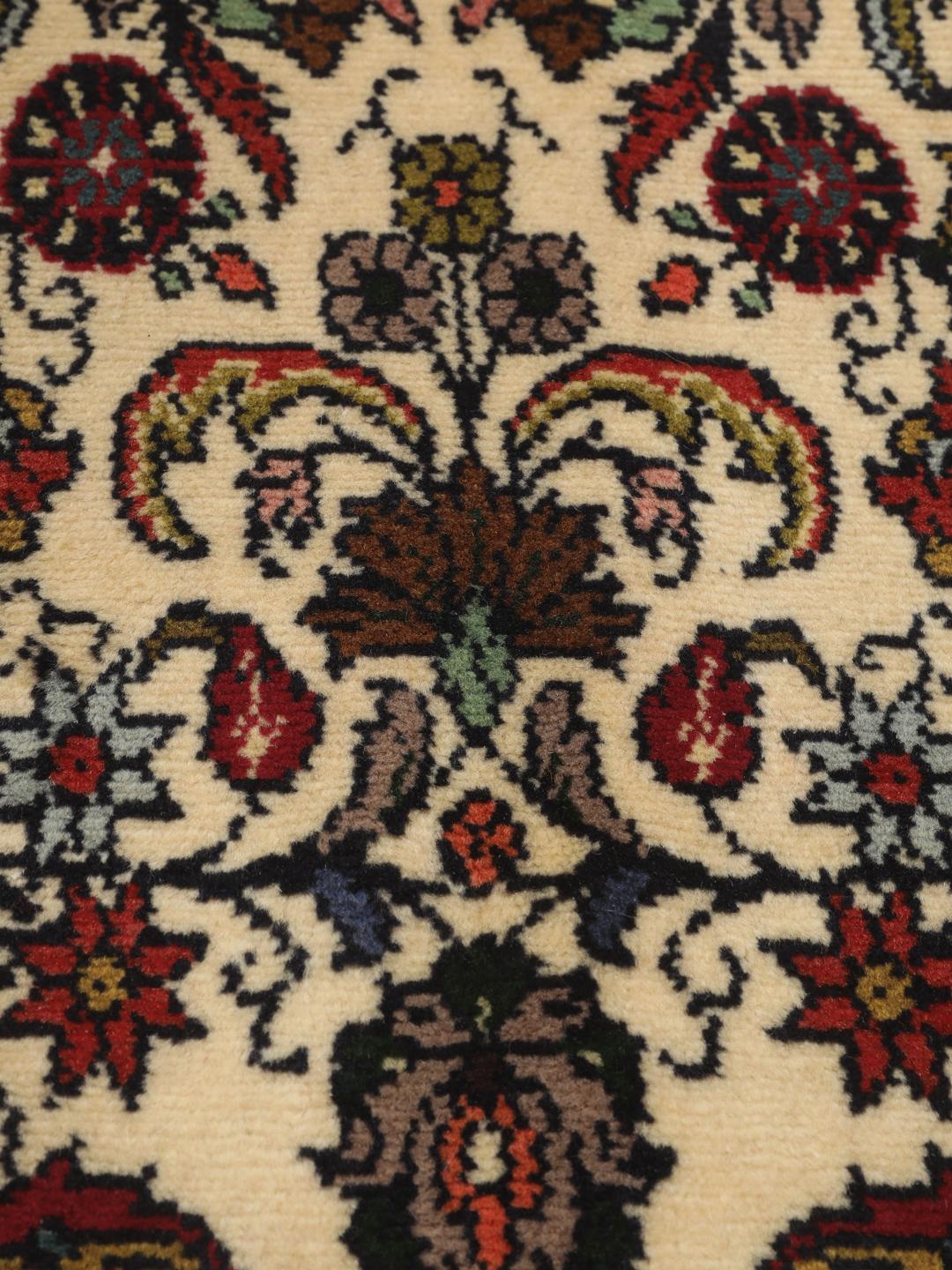 Een met de hand geknoopte Asadabad loper met een bloemmotief in beige, rode en blauwe tinten.
