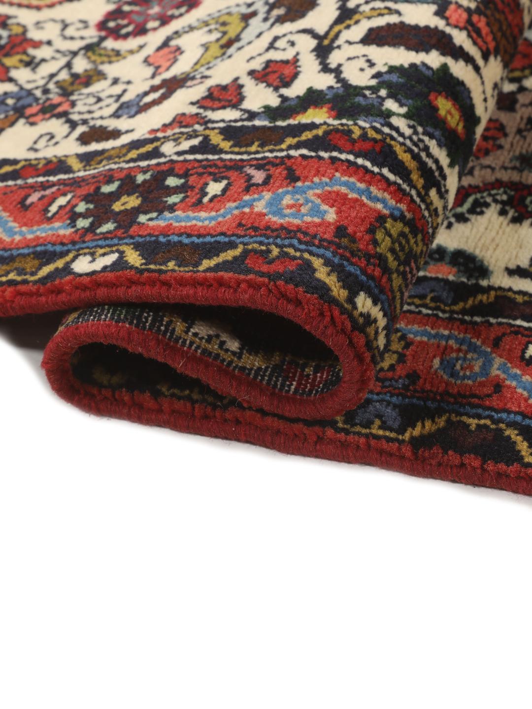 Een met de hand geknoopte Asadabad loper met een bloemmotief in beige, rode en blauwe tinten.