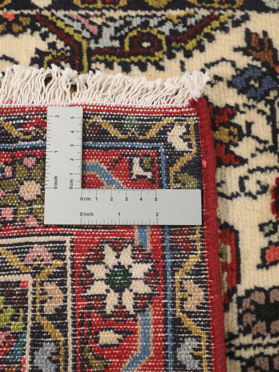 Een met de hand geknoopte Asadabad loper met een bloemmotief in beige, rode en blauwe tinten.