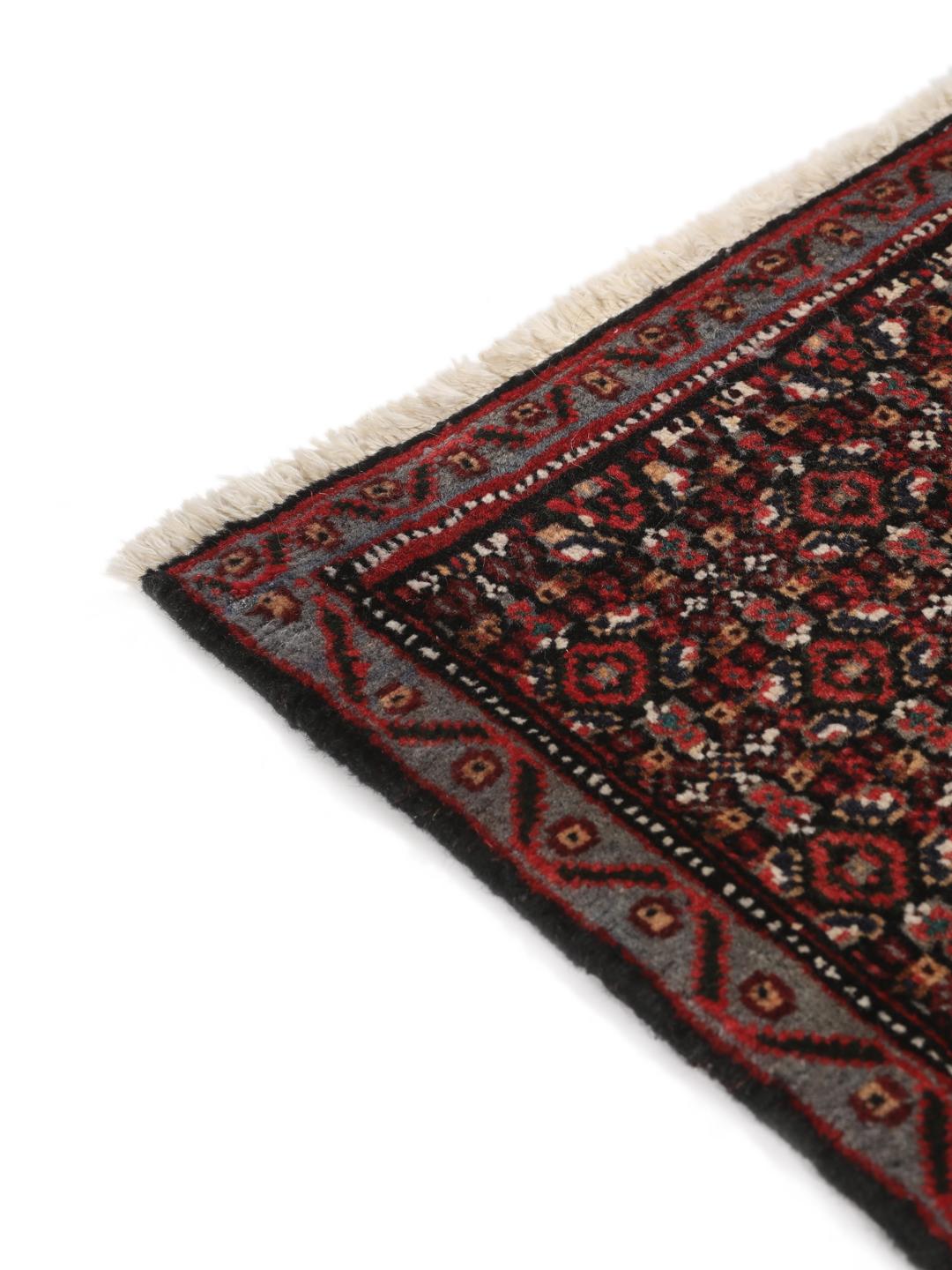 Hand-knotted Senneh rug from the Middle East in dark-red and black tones.
