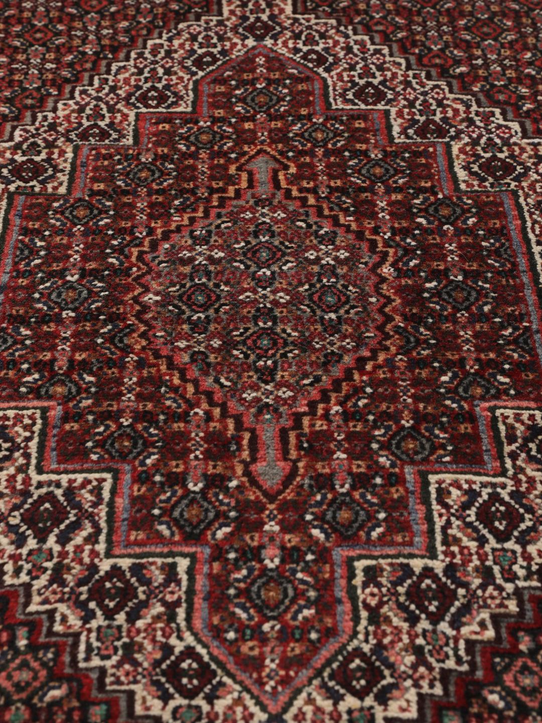 Hand-knotted Senneh rug from the Middle East in dark-red and black tones.