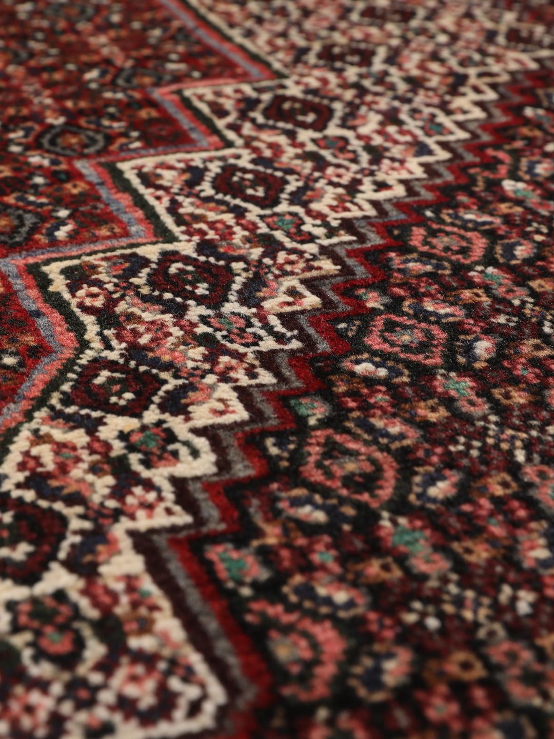 Hand-knotted Senneh rug from the Middle East in dark-red and black tones.