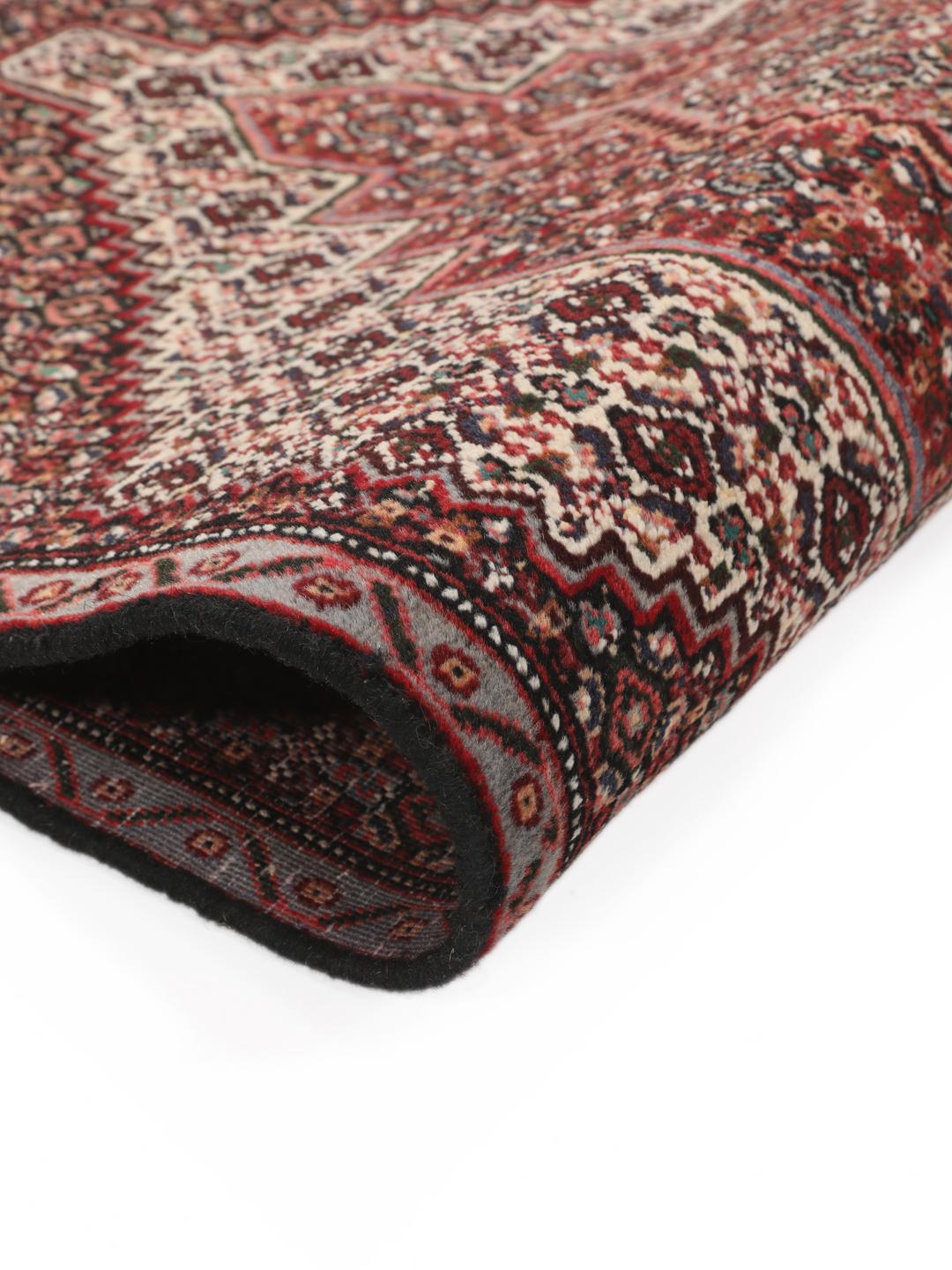 Hand-knotted Senneh rug from the Middle East in dark-red and black tones.