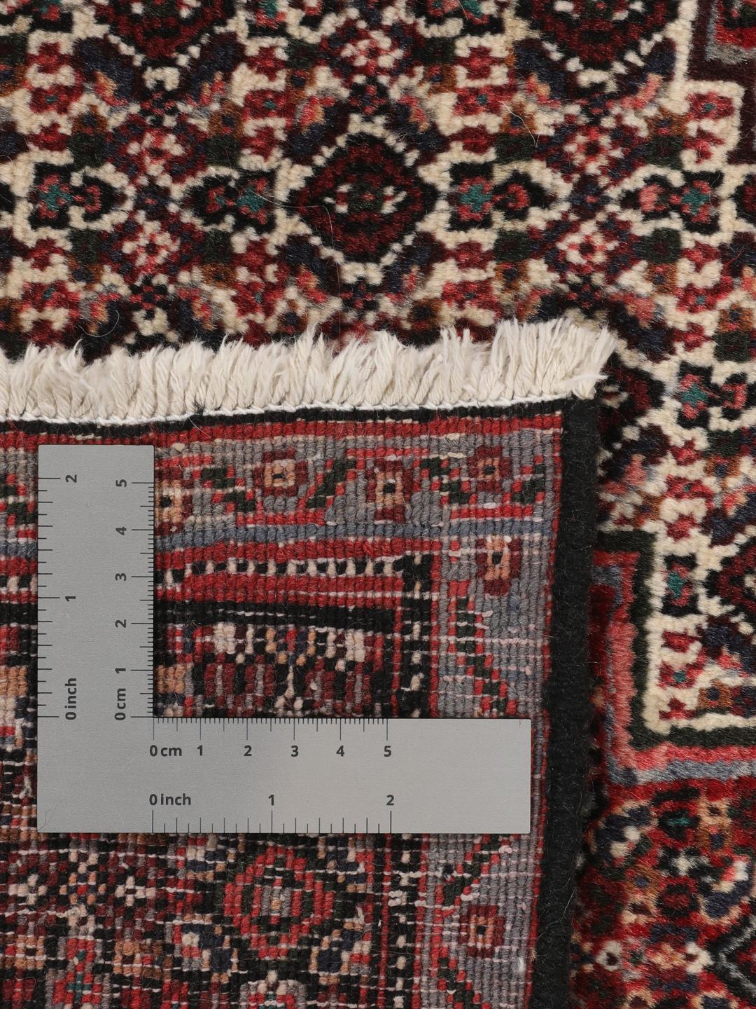 Hand-knotted Senneh rug from the Middle East in dark-red and black tones.