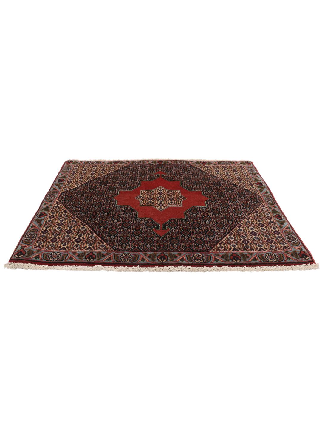 A hand-knotted Senneh rug from the Middle East featuring a red and dark-blue patterned design.