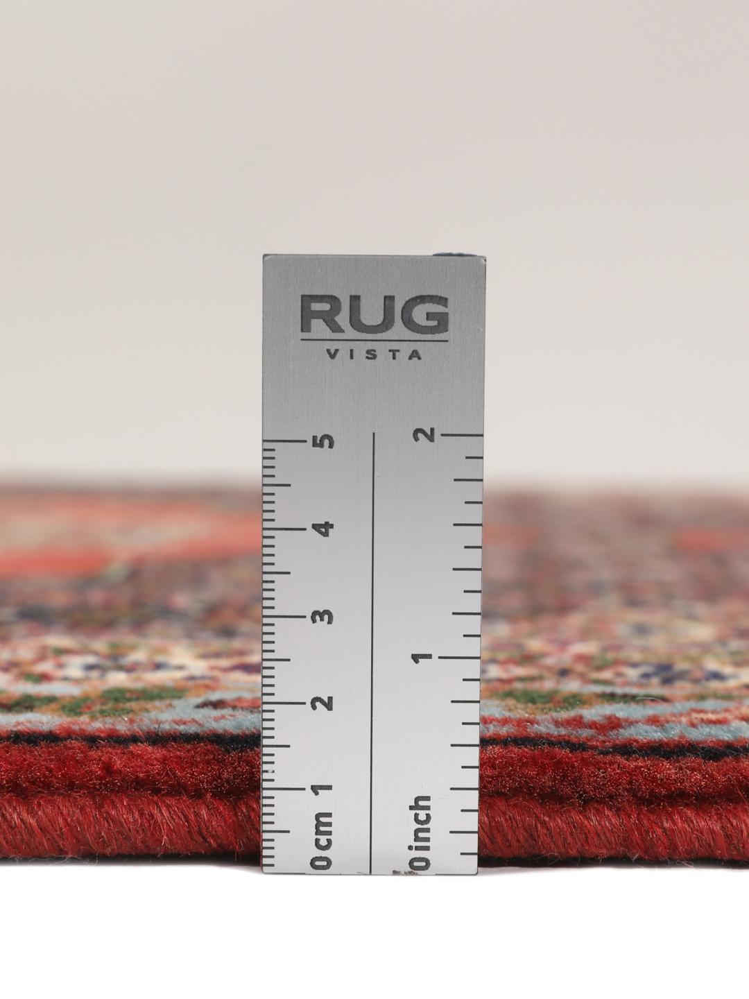 A hand-knotted Senneh rug from the Middle East featuring a red and dark-blue patterned design.