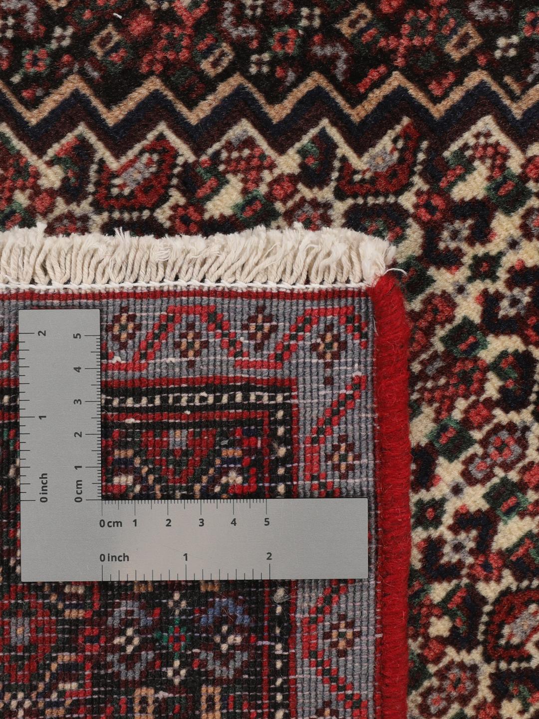 Ein handgeknüpfter Senneh-Teppich mit einem dunkelroten und schwarzen geometrischen Muster.